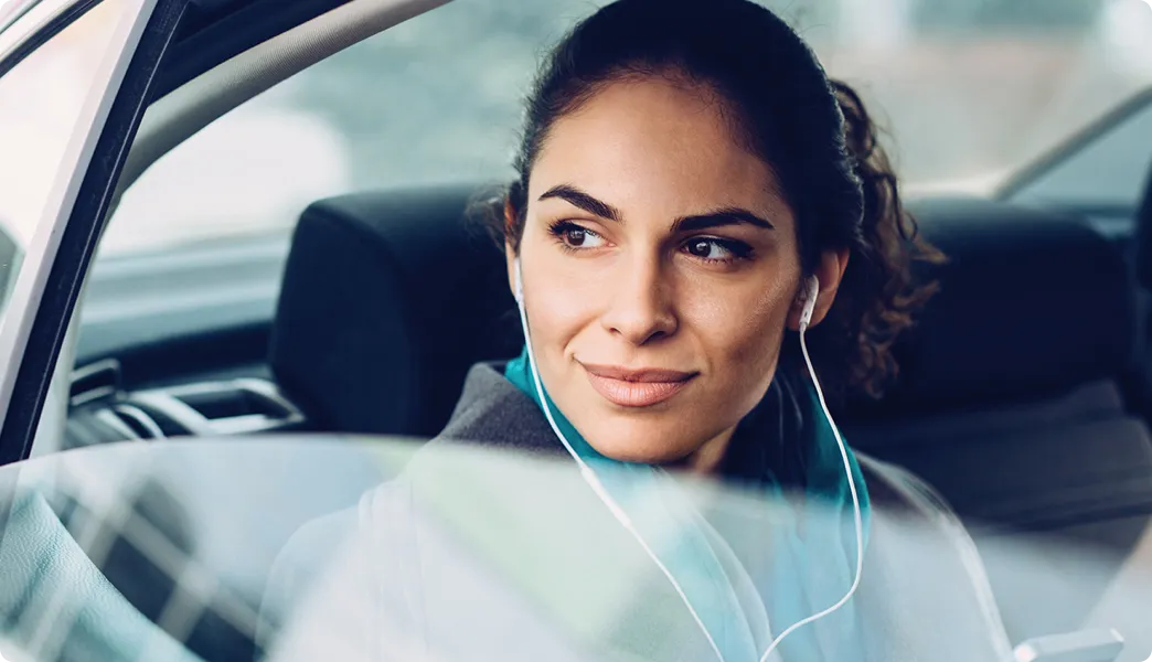 Frau sitzt mit heruntergelassener Scheibe im Auto