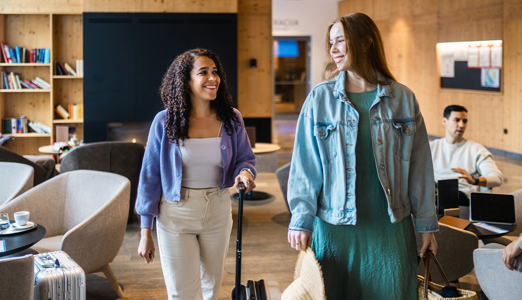 Zwei Frauen mit Gepäck in der Flughafen-Lounge