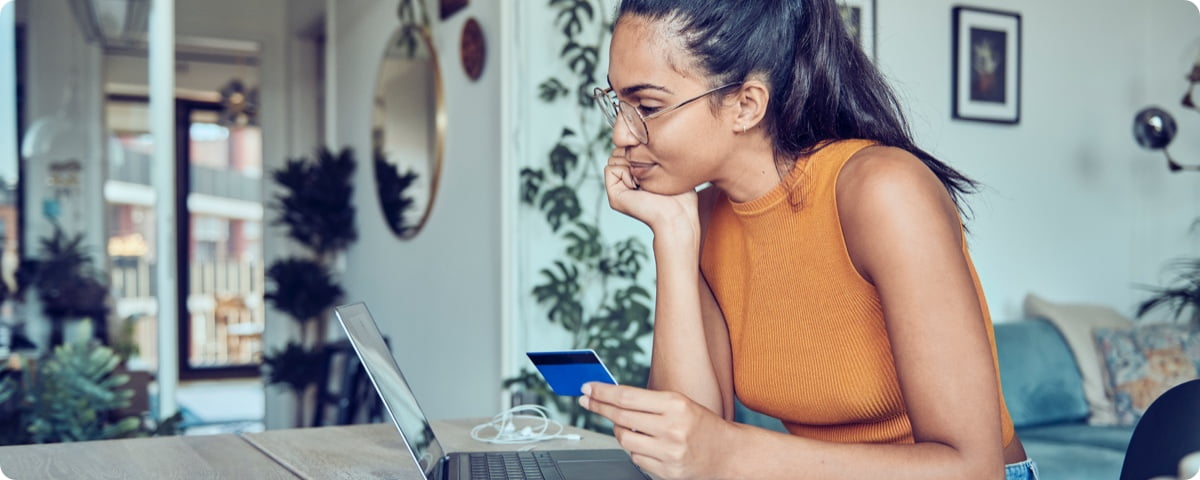 Frau mit PAYBACK American Express Karte vor einem Laptop