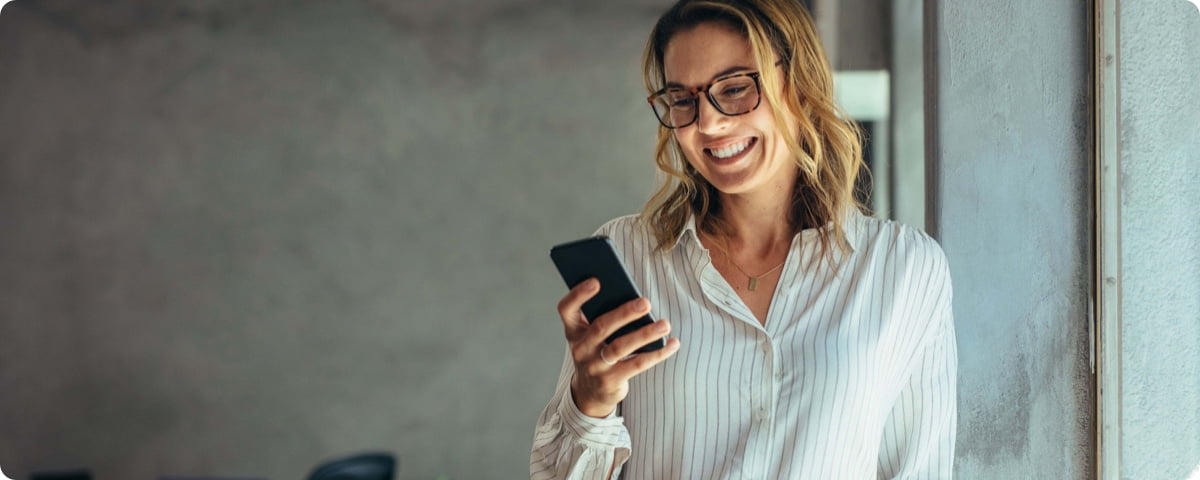 Frau mit Smartphone in der Hand im Büro