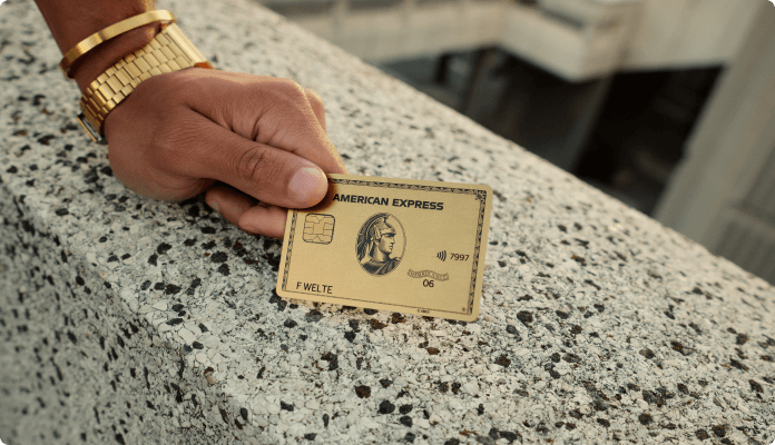 Eine männliche Hand mit der Gold Card aus Metall