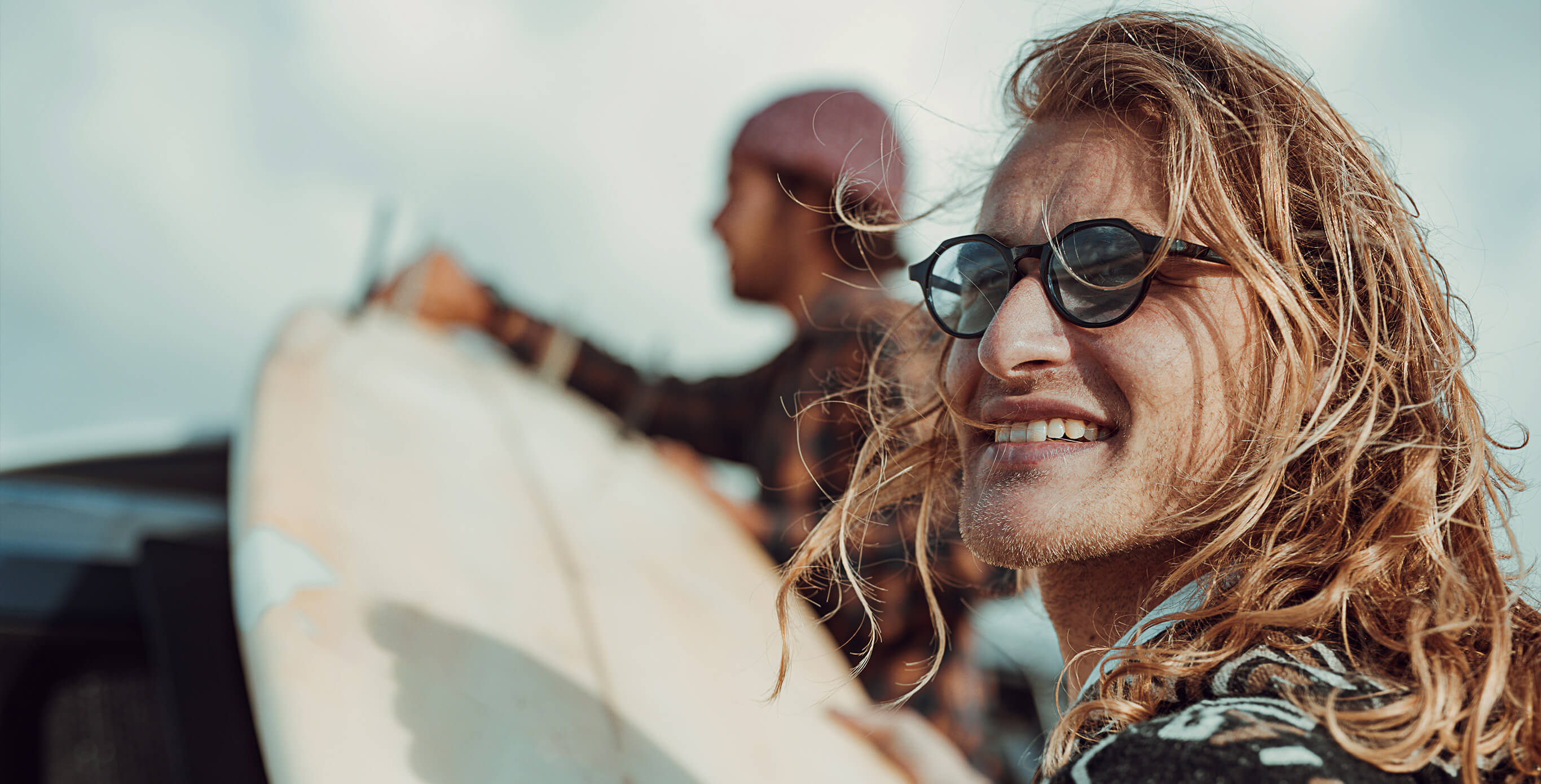 Zwei Surfer laden ihre Surfbretter aufs Auto