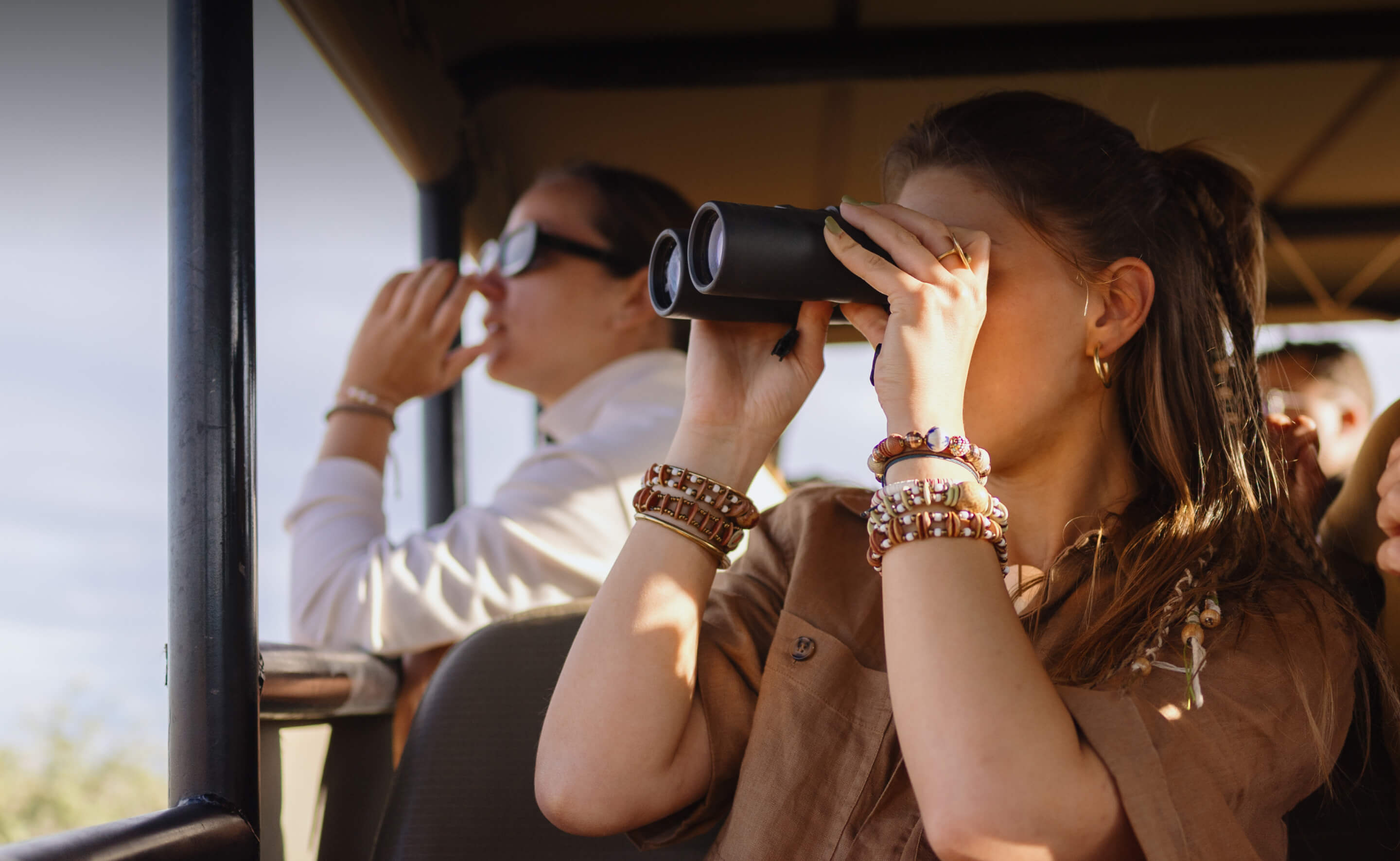 Frau mit Fernglas bei einer Safari