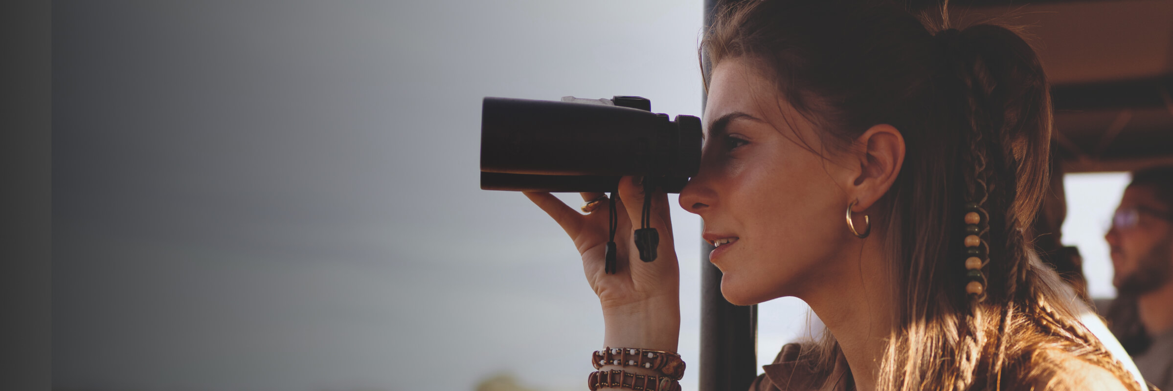 Frau mit Fernglas auf Safari